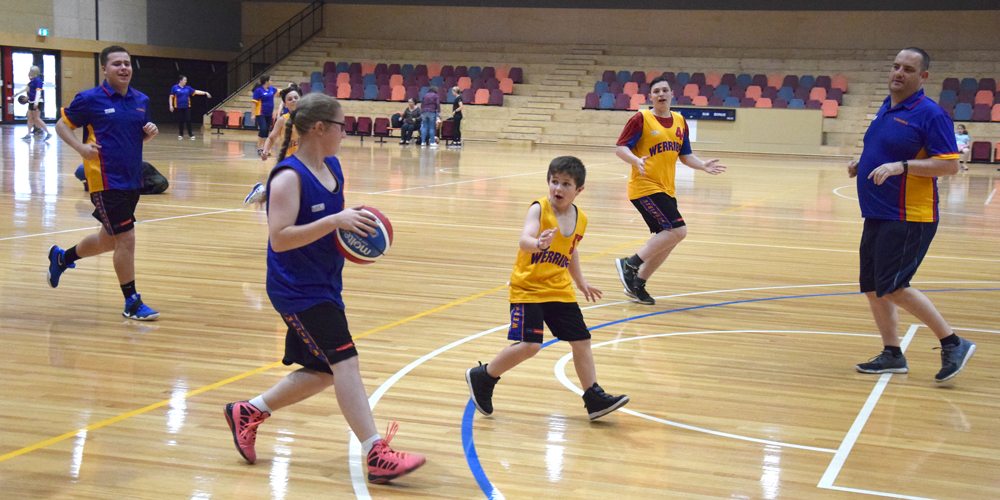 People of all abilities playing basketball together at Eagle Stadium.
